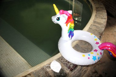 Havuz, parmak arası terliklerin ve Covid-19 salgınının yeni normalliği için yüz maskeli şişirilebilir tek boynuzlu atın yanında oynanacak.