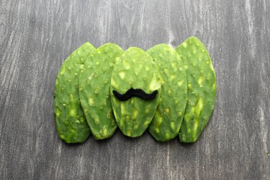 Bıyıklı, papyonlu, tahta masada Meksika tarzı şenlikli ve Meksika partisi için hazır bir tahta kesim tahtası.