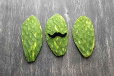 Bıyıklı, papyonlu, tahta masada Meksika tarzı şenlikli ve Meksika partisi için hazır bir tahta kesim tahtası.