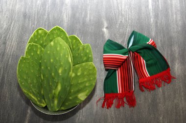 Şenlikli Meksika nesneleri: el yapımı oyuncak bebek ve üç renkli kravat nopalların yanında eğilir, tipik bir Meksika yemeği kesme tahtasında