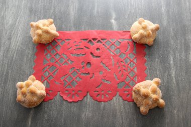 Tahta masadaki Papel Picado masa örtüsü Meksika Ölüler Günü süslemesi gibi Lezzetli, pofuduk ve şekerli ölü ekmeğiyle