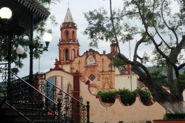 Sierra Gorda de Quertaro 'daki büyülü Jalpan de Serra kasabasının merkezinde kilise önünde bir büfe ve taş çeşmesi olan Fransisken misyonu.