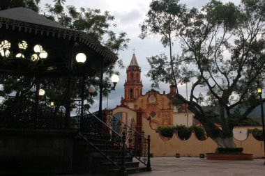 Sierra Gorda de Quertaro 'daki büyülü Jalpan de Serra kasabasının merkezinde kilise önünde bir büfe ve taş çeşmesi olan Fransisken misyonu.