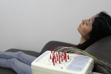 Beyin elektriksel aktivitesini ölçmek ve epilepsi ve uyku bozuklukları gibi beyin sorunlarını teşhis etmek için 20 yaşındaki Latin bir kadına elektroensefalogram.
