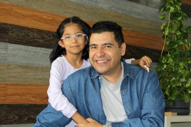 Boşanmış bekar bir baba, 5 yaşındaki Latin kızıyla oynar. Gözlüklü bir esmer, sevgilerini gösterir ve Babalar Günü 'nü kutlar.