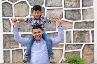 Boşanmış bekar baba, 7 yaşındaki koyu latin oğlunu sırtında sırtında taşıyor ve Babalar Günü 'nü kutluyor.