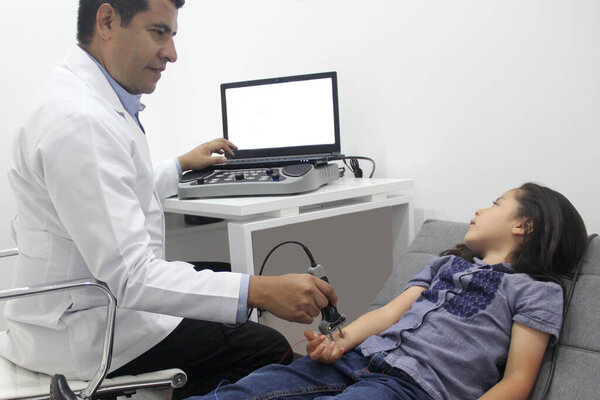 Электромиография ЭМГ и Nerve Conduction Velocity NCV руки и руки у 6-летней латиноамериканки с врачом