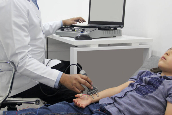 Электромиография ЭМГ и Nerve Conduction Velocity NCV руки и руки у 6-летней латиноамериканки с врачом