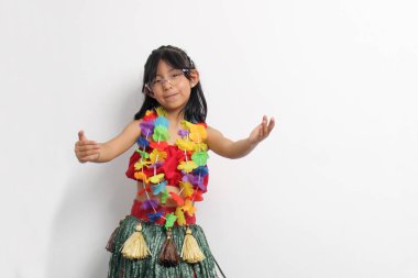 Kahverengi saçlı 5 yaşındaki Latin kız Hawaii dansını öğrenmeyi, renkli bir etek ve kolye giymeyi ve hareketlerini göstermeyi seviyor.