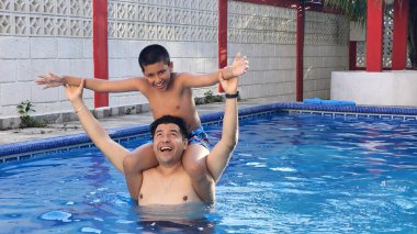 Boşanmış bekar baba ve 11 yaşındaki Latin oğlu havuzda oynuyorlar ve tatillerinde ona yüzmeyi öğretiyorlar.