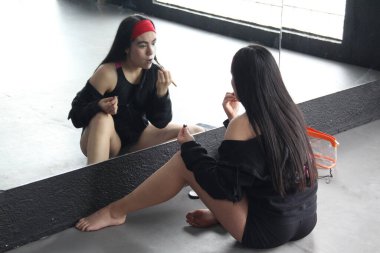 Meksika 'daki Ölü Parti Günü' nü kutlamak için genç Meksikalı kadın aynanın karşısına geçip kedi makyajı yapıyor.