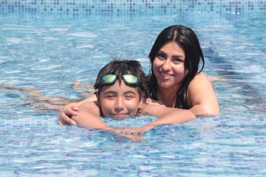 11 yaşındaki küçük Latin oğluyla havuzda yüzüp, eğlenen genç bekar anne ve sıcak hava dalgası.