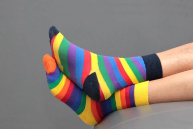 Uyumsuz çoraplı ayaklar, Dünya Down Sendromu Günü için farklı renkler ve tasarımlar, her bir insanın benzersizliğini vurgulamak için.