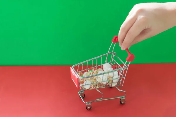 Bir Kırmızı Yeşil Arka Planda Ilaç Dolu Bir Alışveriş Sepetini — Stok fotoğraf