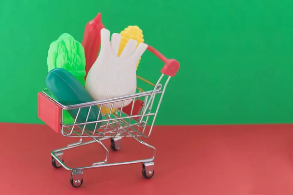 Kırmızı Yeşil Arka Planda Plastik Sebzeli Alışveriş Arabası Zararlı Katkı — Stok fotoğraf