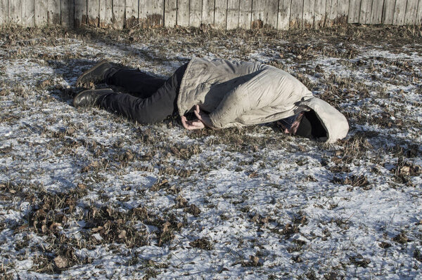 Murder. The body of a man lies on the melting snow. Brutal crime. Close up.