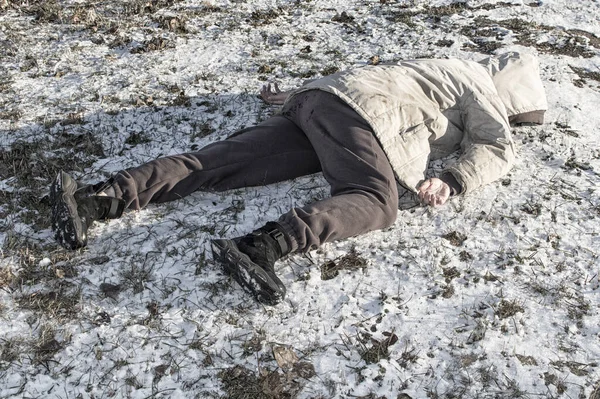 Murder. The body of a man lies on the melting snow. Brutal crime. Close up.