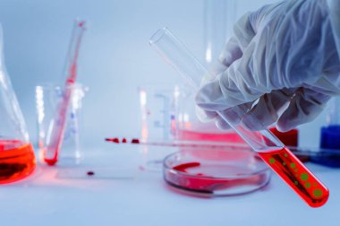 İlaçlar. Eldivenli bir el, içinde virüs olan bir test tüpü tutuyor. Bitmap çiziminin elementleri. Yapay virüs konsepti. Yakın plan..