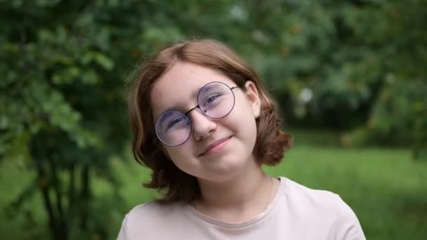 안경을 소녀는 공원의 카메라 앞에서 웃음거리가 얼굴을 과즐길 — 비디오