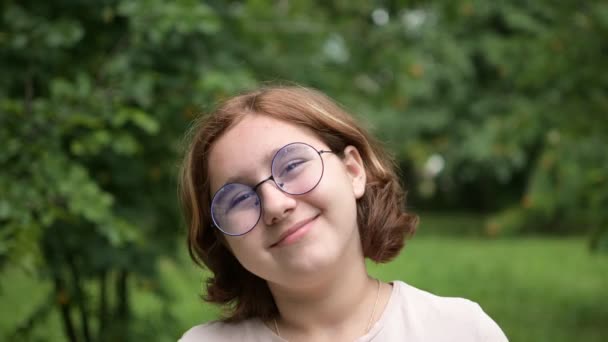 Una Adolescente Con Gafas Hace Caras Graciosas Cámara Del Parque — Vídeo de stock