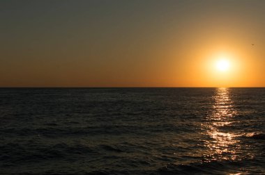 Manzara. Deniz kıyısında güneşli bir gün batımı.
