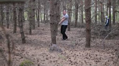 Genç kızı olan bir adam mantar aramak için sık bir ormanda yürür.