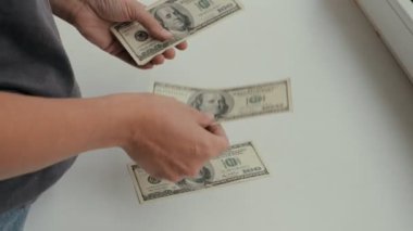 Bir insan paranın büyük olduğunu düşünür. 100 dolarlık banknotlar, nakit ödemeler yatırım, başarı, kariyer büyümesi konsepti.