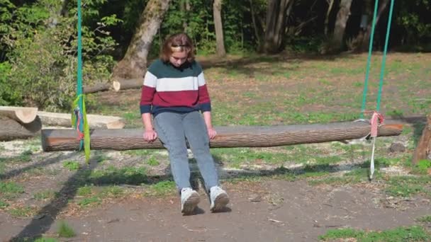 Egy Tinédzser Lány Színes Pulóverben Hintázik Egy Hosszú Hintán Fából — Stock videók