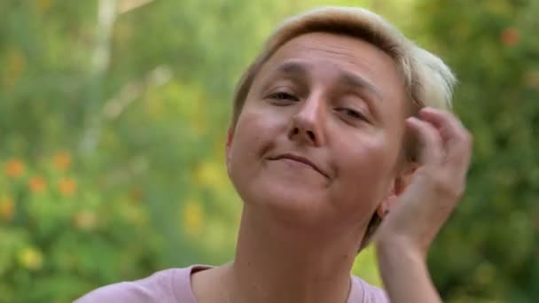 Blondýnka Krátkým Sestřihem Upraví Její Vlasy Rukama Pozadí Zelené Přírody — Stock video
