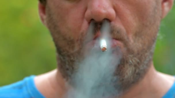 Neoholený Muž Plnovousem Kouří Cigaretu Kouří Pozadí Zelené Přírody Zblízka — Stock video