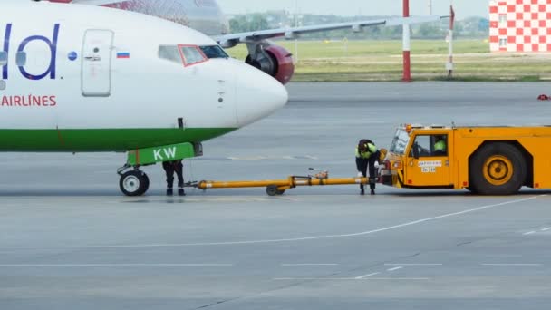 Závěsu traktoru tlačí S7 Airlines letadlo — Stock video