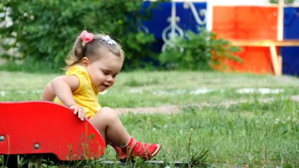 Meisje is lachen zittend op een dia childrens — Stockvideo