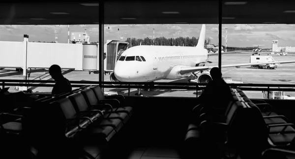 Menschen, die am Flughafen auf ihre Abfahrt warten — Stockfoto