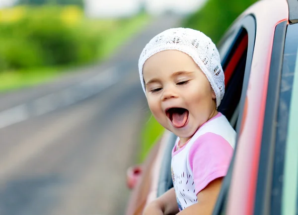 Retrato de menina criança feliz colando a cabeça para fora a vitória do carro — Fotografia de Stock