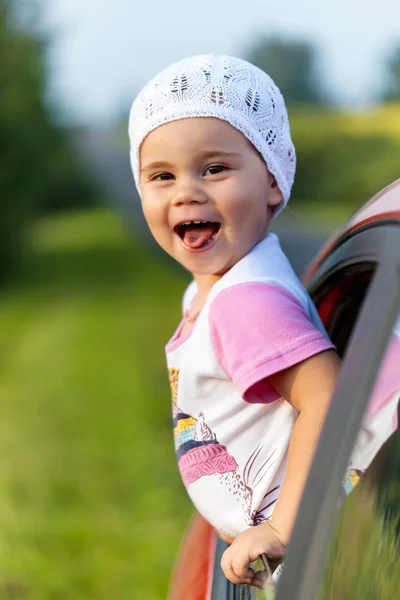 Portrait of happy child girl sticking their head out the car win — Stock Photo, Image