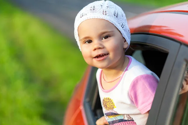 Ritratto di ragazza felice bambino attaccare la testa fuori la vittoria auto — Foto Stock