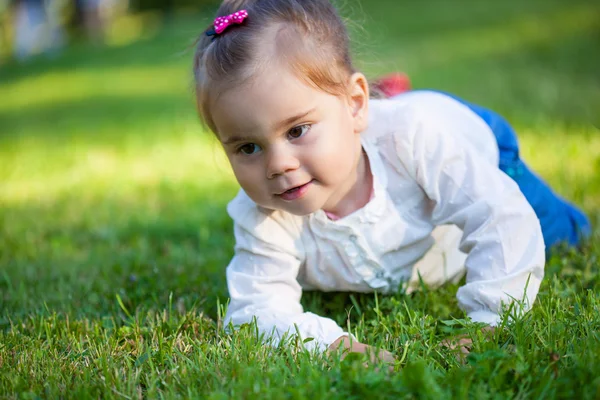 Little child girl lying on field — Stock Photo, Image