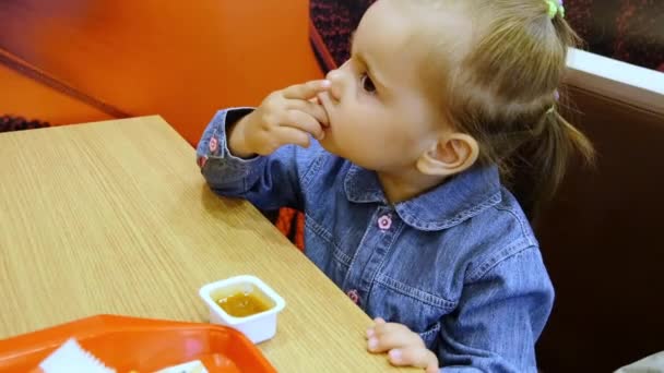 Little girl eating french fries in cafe — Stock Video