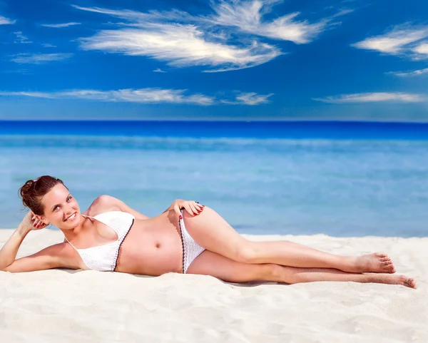 Mujer en traje de baño blanco relajante en la playa tropical — Foto de Stock