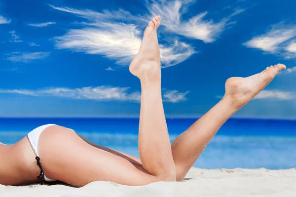 Sexy womans legs against the turquoise sea background — Stock Photo, Image