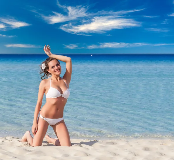 Mulher de fato de banho branco relaxante na praia tropical — Fotografia de Stock