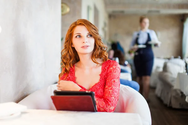 Aantrekkelijke jonge vrouw met tablet in café — Stockfoto