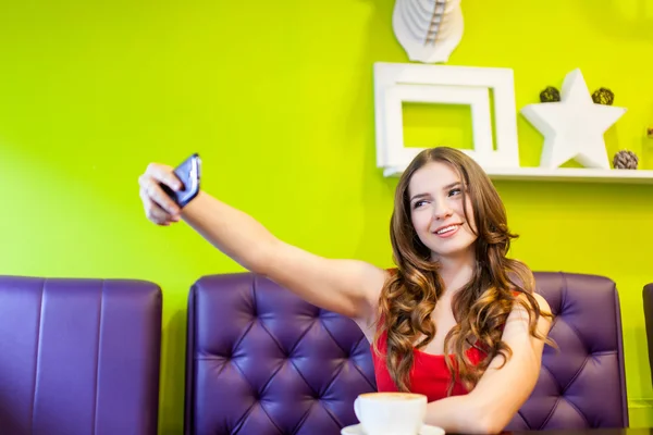 Vrouw neemt selfie in een café — Stockfoto