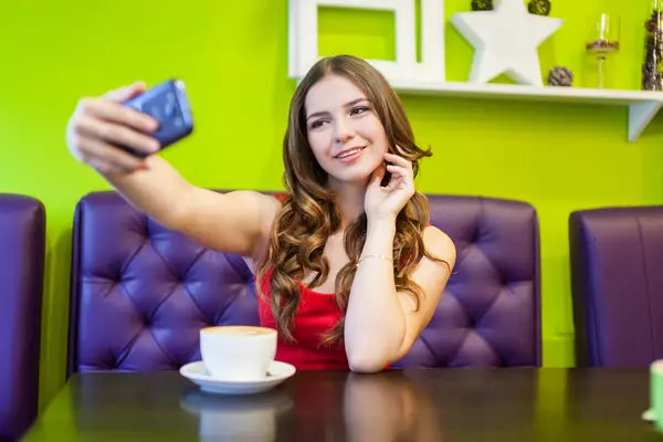 Kobieta jest biorąc selfie w kawiarni — Zdjęcie stockowe