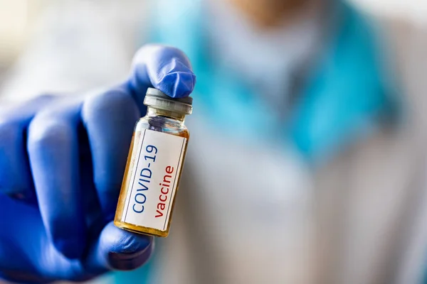 Medical doctor holding tube with nCoV Coronavirus vaccine for COVID-19 virus