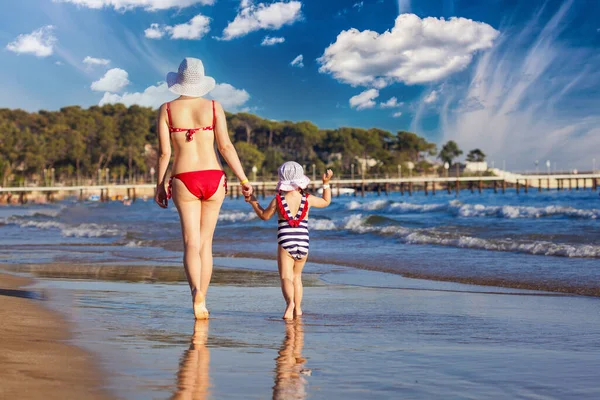 Mutter und Tochter haben Spaß beim Wandern und Spielen am Strand — Stockfoto