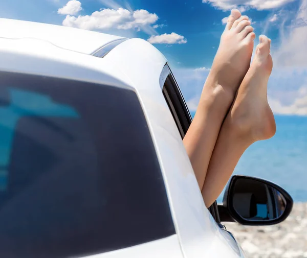 Mujer joven pies desnudos que sobresalen de la ventana blanca del coche — Foto de Stock