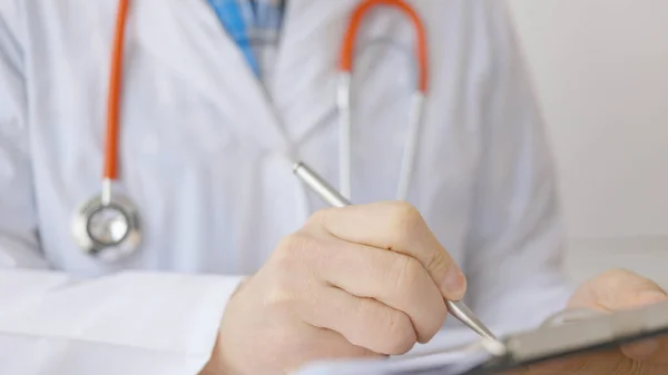 Close-up de médico masculino fazendo uma prescrição na clínica médica. — Fotografia de Stock