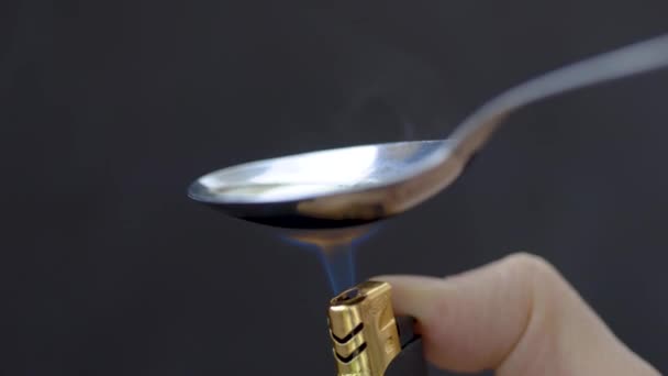 Vista de perto de uma colher com heroína culinária com um isqueiro — Vídeo de Stock