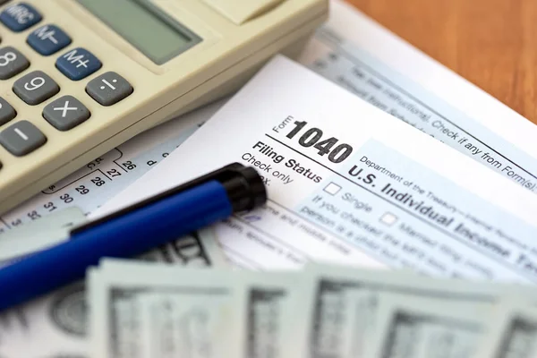 Formulario fiscal individual 1040, calculadora y billetes de cien dólares —  Fotos de Stock
